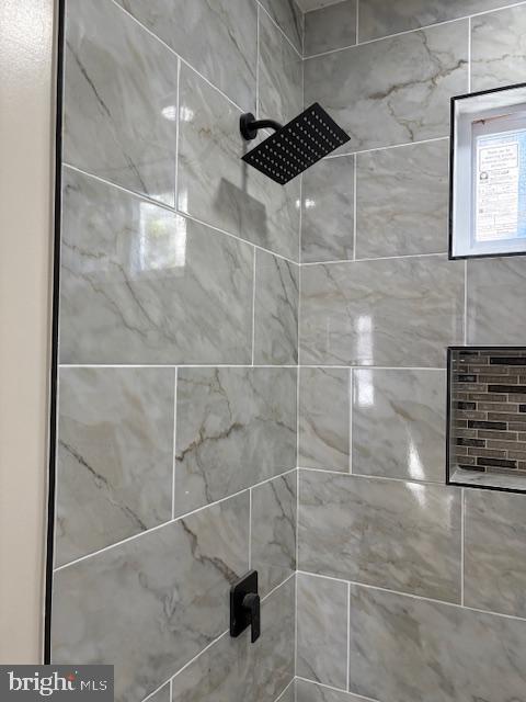 interior details featuring tiled shower