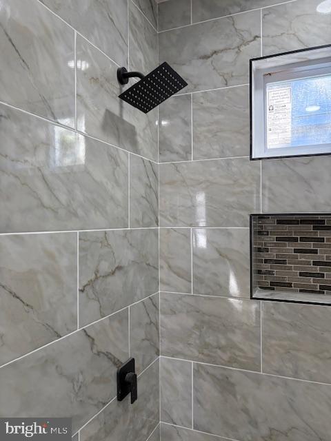 interior details featuring tiled shower