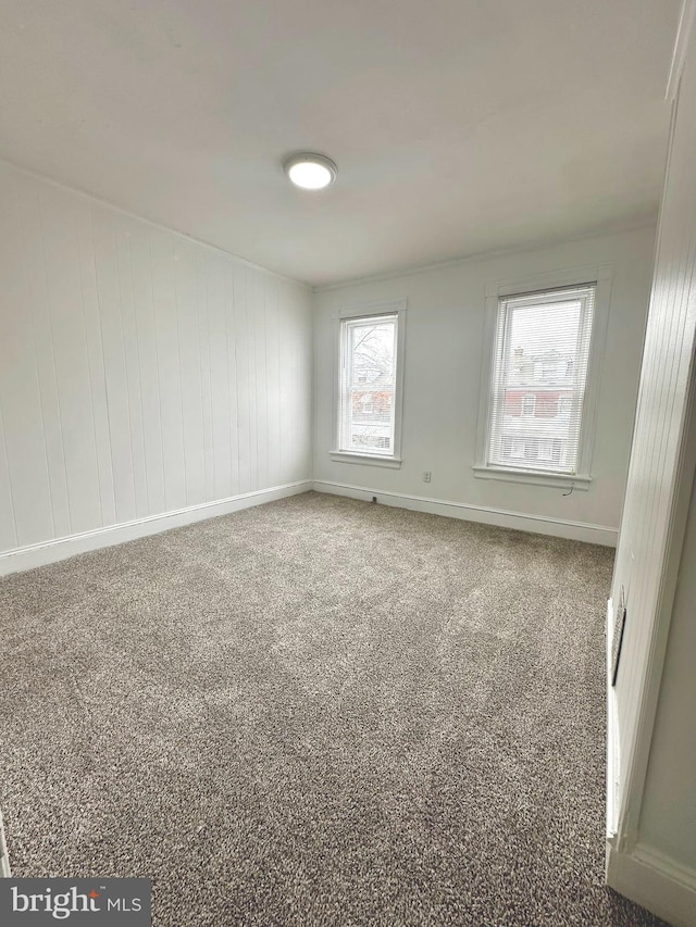 unfurnished room with baseboards and carpet