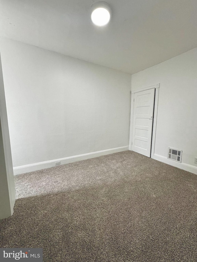 unfurnished room with visible vents, baseboards, and carpet floors