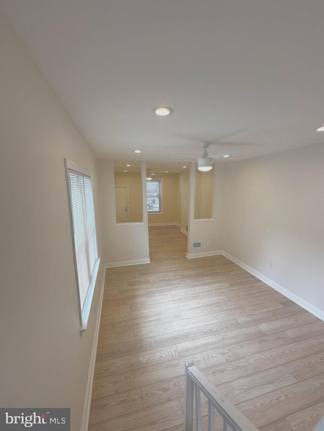 spare room with light wood-type flooring, a ceiling fan, visible vents, recessed lighting, and baseboards