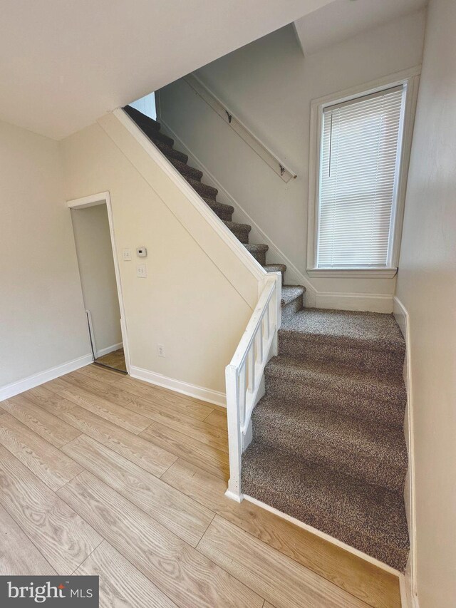 stairs featuring baseboards and wood finished floors