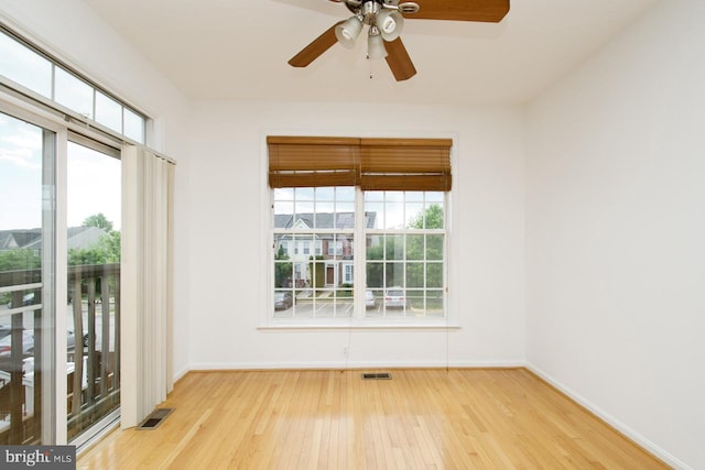 spare room featuring visible vents, wood-type flooring, and baseboards