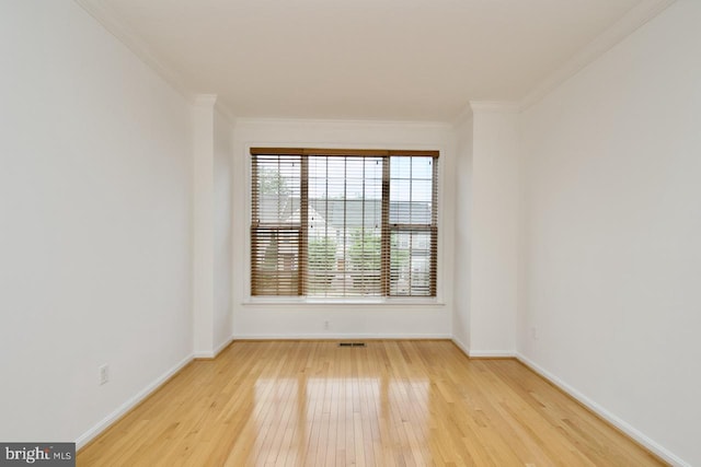 spare room with baseboards, ornamental molding, and hardwood / wood-style flooring