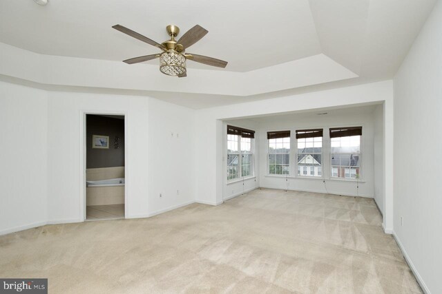 spare room featuring baseboards, light carpet, and a ceiling fan