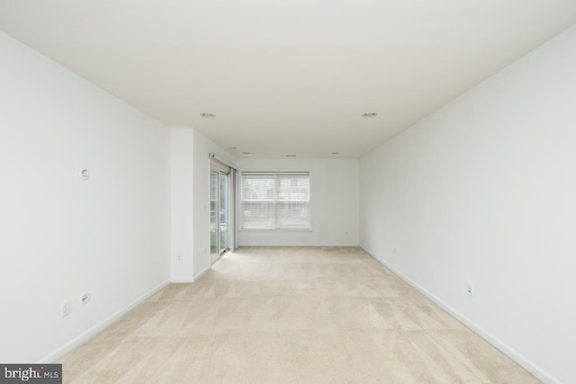 empty room with light colored carpet and baseboards