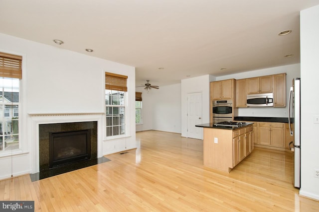 kitchen featuring a kitchen island, stainless steel appliances, open floor plan, and light wood-style floors