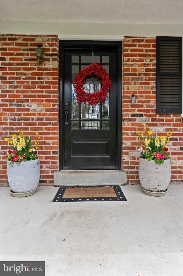 view of exterior entry with brick siding
