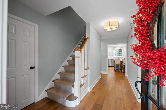 stairs with wood finished floors and baseboards