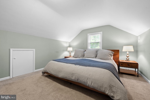 carpeted bedroom with vaulted ceiling and baseboards