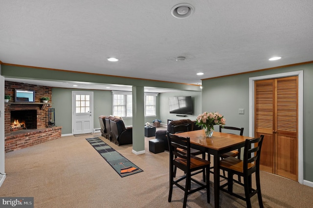 dining space featuring a baseboard heating unit, recessed lighting, a textured ceiling, and a fireplace