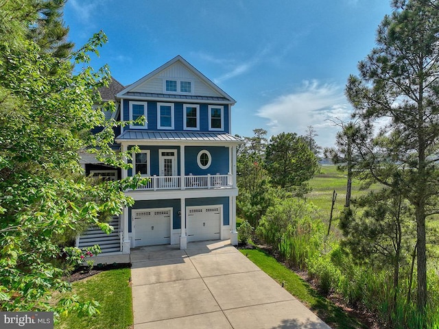 169 E Buckingham Dr, Rehoboth Beach, DE 19971 - coastal home featuring concrete driveway, a standing seam roof, an attached garage, metal roof, and a porch