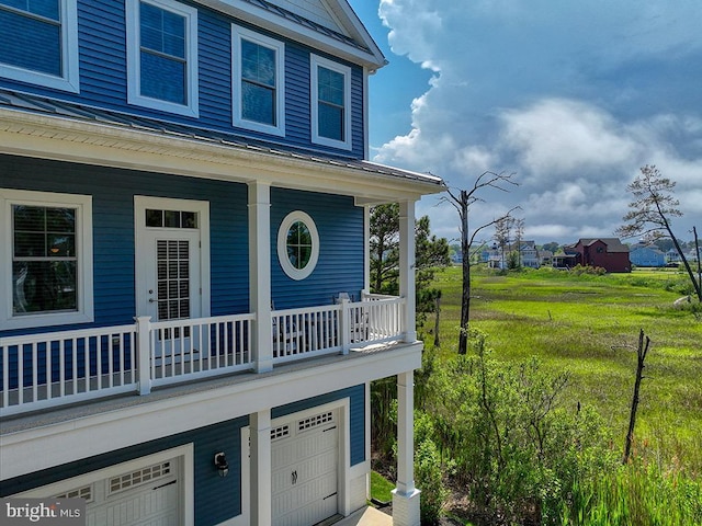 169 E Buckingham Dr, Rehoboth Beach, DE 19971 - view of exterior entry featuring an attached garage, a porch, and a balcony