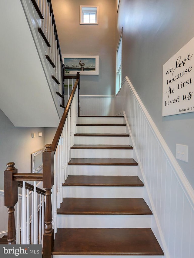 169 E Buckingham Dr, Rehoboth Beach, DE 19971 - stairs with a towering ceiling, wainscoting, and a decorative wall