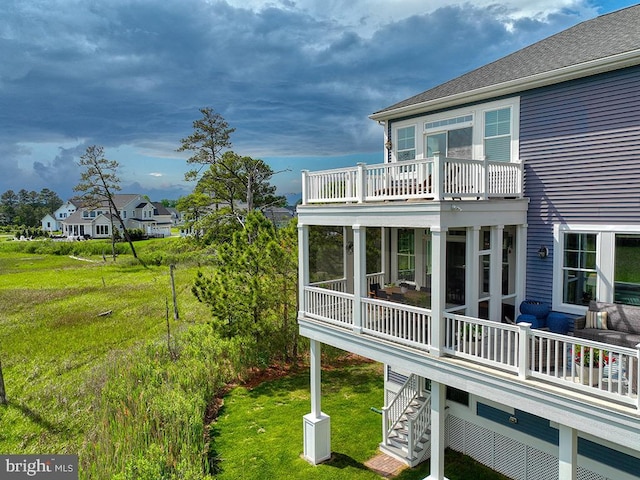 169 E Buckingham Dr, Rehoboth Beach, DE 19971 - view of property exterior featuring a balcony, a yard, a sunroom, stairs, and a residential view
