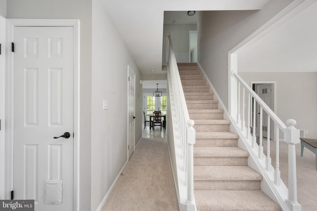 staircase with baseboards and carpet floors