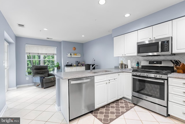 12310 Rosslare Ridge Rd Unit 301, Lutherville Timonium, MD 21093 - kitchen with stainless steel appliances, a sink, a peninsula, decorative backsplash, and white cabinetry