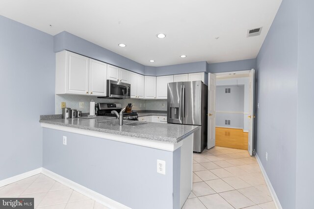 12310 Rosslare Ridge Rd Unit 301, Lutherville Timonium, MD 21093 - kitchen featuring appliances with stainless steel finishes, a peninsula, light tile patterned floors, white cabinetry, and recessed lighting