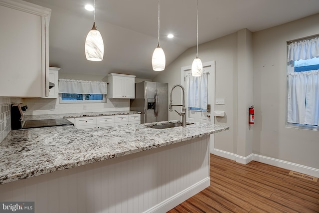 kitchen featuring white cabinetry, visible vents, stainless steel appliances, a sink, and wood finished floors