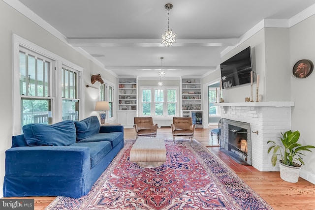 living area with a fireplace, wood finished floors, built in shelves, beam ceiling, and baseboards