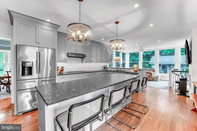kitchen featuring stainless steel fridge with ice dispenser, a chandelier, gray cabinetry, gas stovetop, and recessed lighting