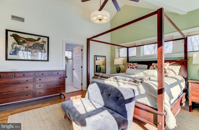 bedroom with high vaulted ceiling and wood finished floors