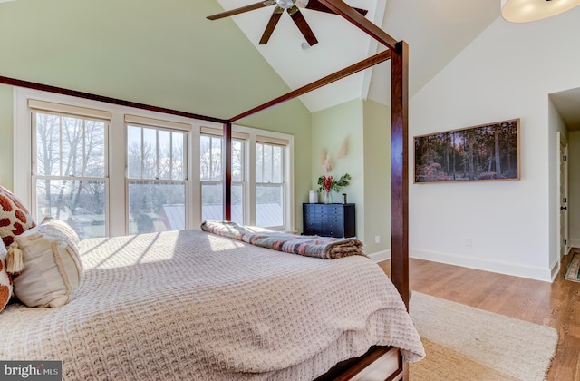 bedroom with wood finished floors, baseboards, high vaulted ceiling, and ceiling fan