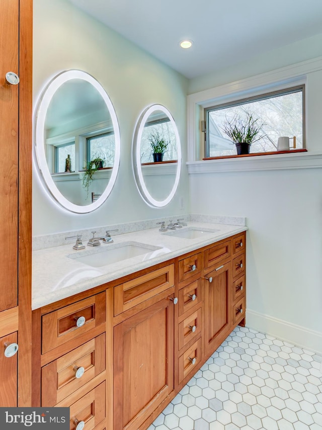bathroom with double vanity, tile patterned floors, and baseboards