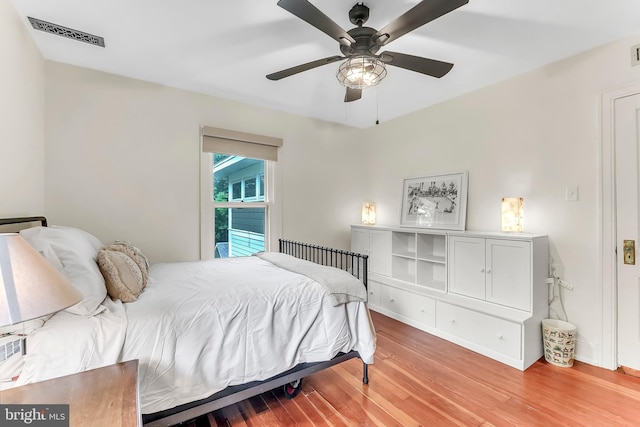 bedroom featuring light wood-style floors, a ceiling fan, and baseboards