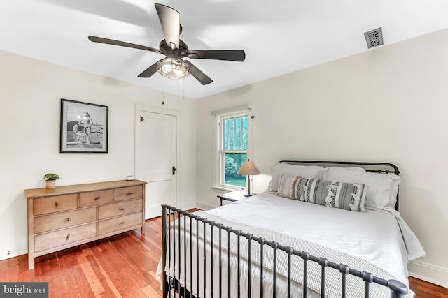 bedroom with baseboards, wood finished floors, and a ceiling fan