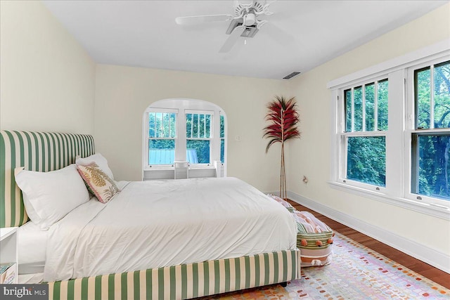 bedroom with wood finished floors, baseboards, and ceiling fan