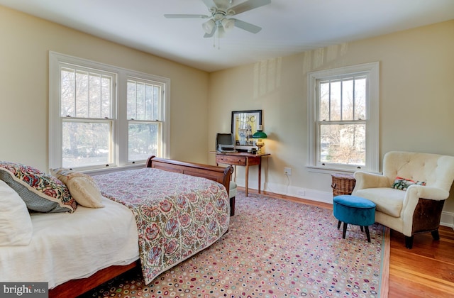 bedroom featuring wood finished floors, baseboards, and ceiling fan