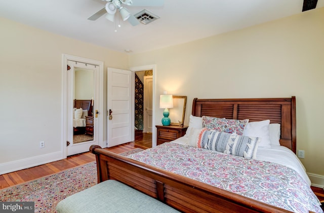 bedroom featuring baseboards, wood finished floors, and a ceiling fan