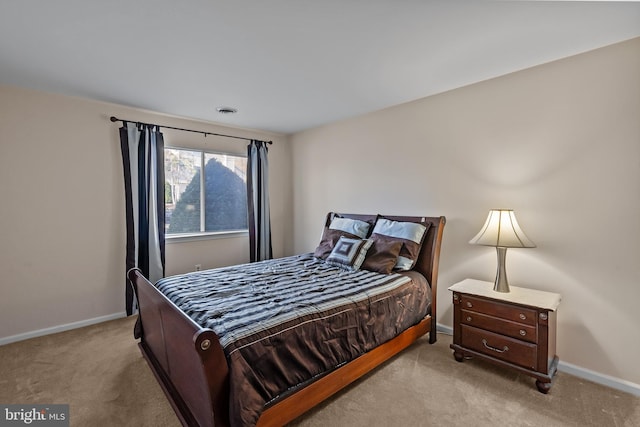 bedroom with visible vents, baseboards, and light carpet
