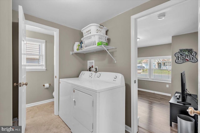 laundry area featuring plenty of natural light, washing machine and dryer, laundry area, and baseboards