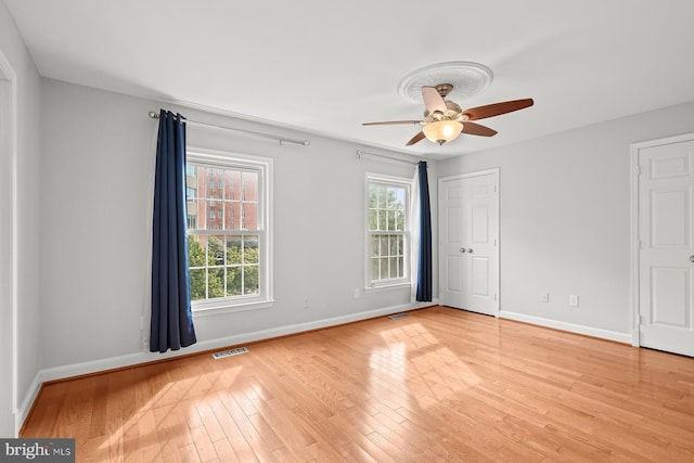 unfurnished bedroom with visible vents, light wood finished floors, baseboards, and ceiling fan