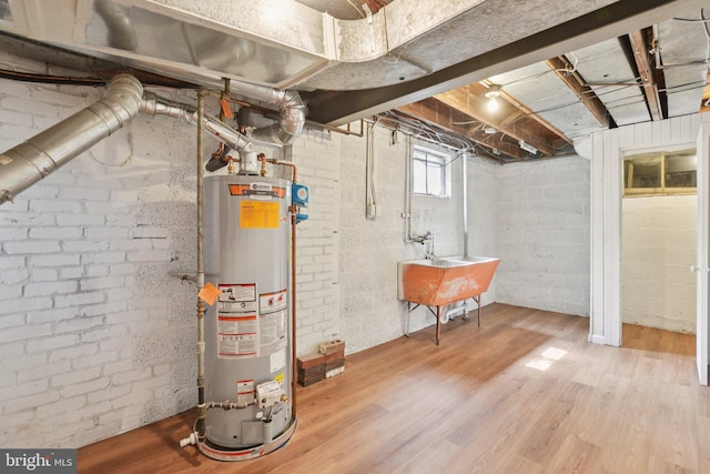 206 E Indian Spring Dr, Silver Spring, MD 20901 - below grade area with water heater, wood finished floors, a sink, and brick wall