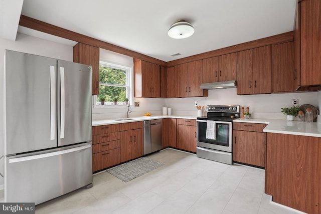206 E Indian Spring Dr, Silver Spring, MD 20901 - kitchen with stainless steel appliances, light countertops, a sink, under cabinet range hood, and brown cabinetry