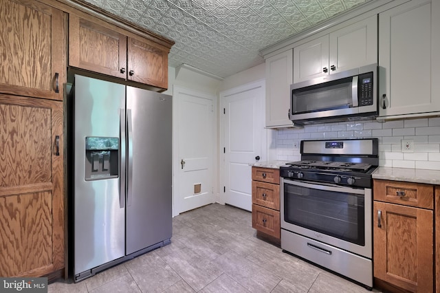 1221 Elm Ave, Lancaster, PA 17603 - kitchen with appliances with stainless steel finishes, an ornate ceiling, decorative backsplash, light stone countertops, and brown cabinetry