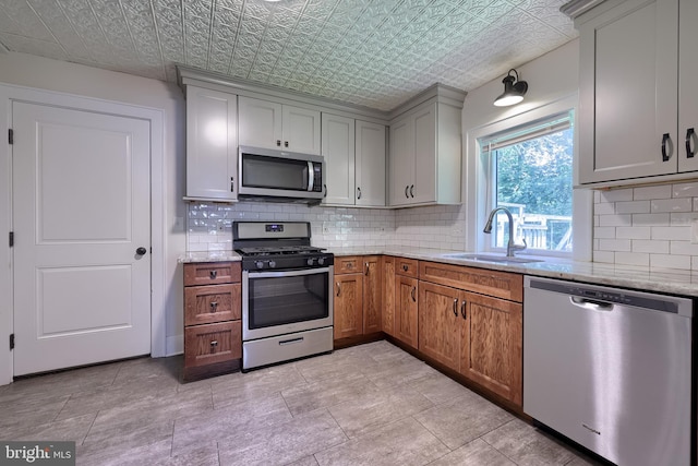 1221 Elm Ave, Lancaster, PA 17603 - kitchen featuring appliances with stainless steel finishes, a sink, an ornate ceiling, backsplash, and light stone countertops