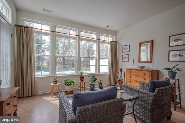 living area with baseboards, visible vents, and light tile patterned floors