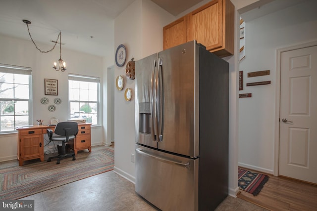 kitchen featuring baseboards, stainless steel fridge, and a chandelier
