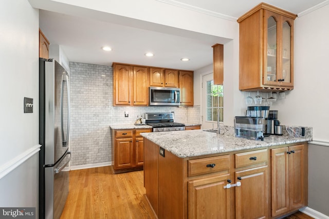 6002 Williamsburg Rd, Alexandria, VA 22303 - kitchen with stainless steel appliances, light wood-style flooring, glass insert cabinets, light stone counters, and a peninsula