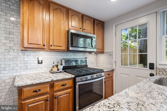 6002 Williamsburg Rd, Alexandria, VA 22303 - kitchen featuring appliances with stainless steel finishes, light stone countertops, and brown cabinets