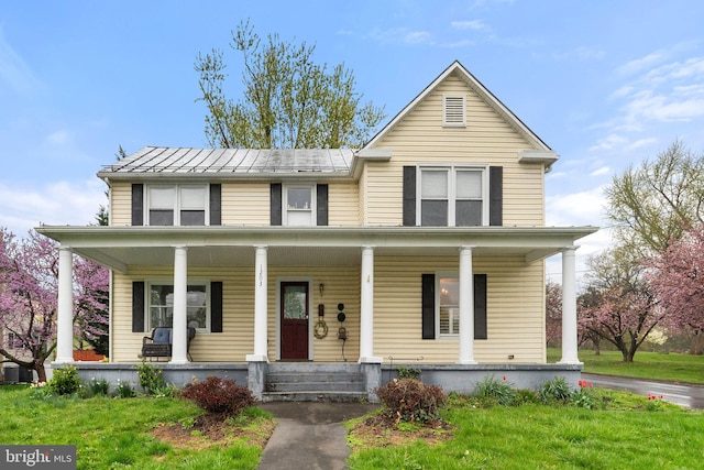 view of front of property with covered porch and a front yard