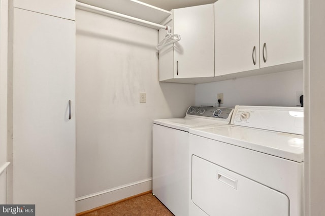 laundry area with cabinet space, baseboards, and washer and dryer