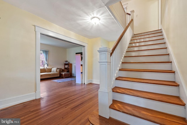 stairway with baseboards and wood finished floors