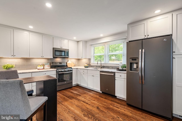 6005 Monticello Rd, Alexandria, VA 22303 - kitchen featuring appliances with stainless steel finishes, a sink, light countertops, white cabinets, and backsplash
