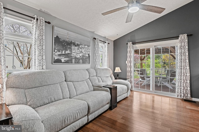 living area featuring ceiling fan, a textured ceiling, vaulted ceiling, and wood finished floors