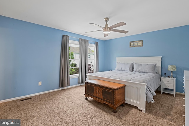 carpeted bedroom with visible vents, a ceiling fan, and baseboards